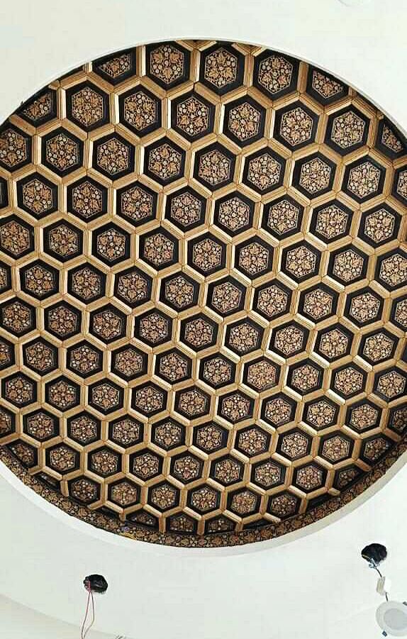 Round khatamband ceiling of gold hexagons on black, each hexagon painted with gold paper machie floral work.